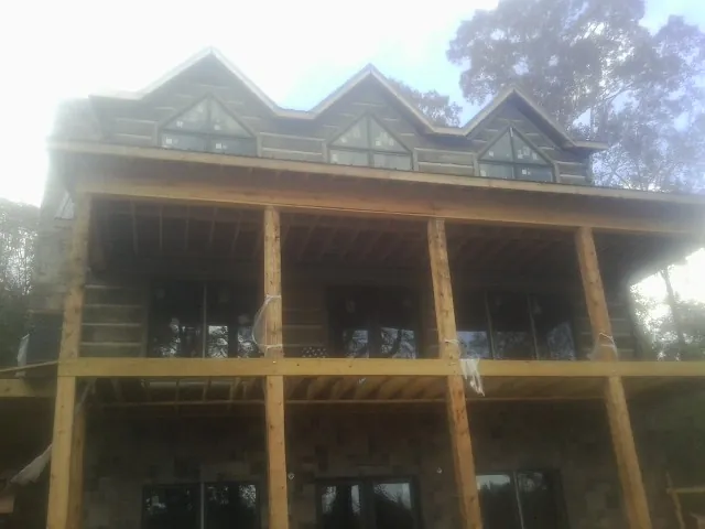 Dormers and porch framing on a large log home under construction — Roof Coating work by our crew in Point Pleasant Beach