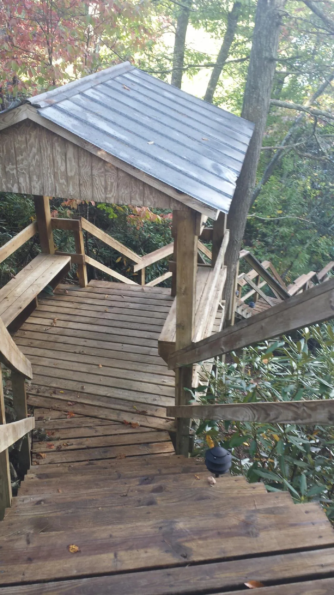 Metal roofed shelter over wooden steps on a wooded walkway — Skylight Repair & Installation work by our crew in Point Pleasant Beach